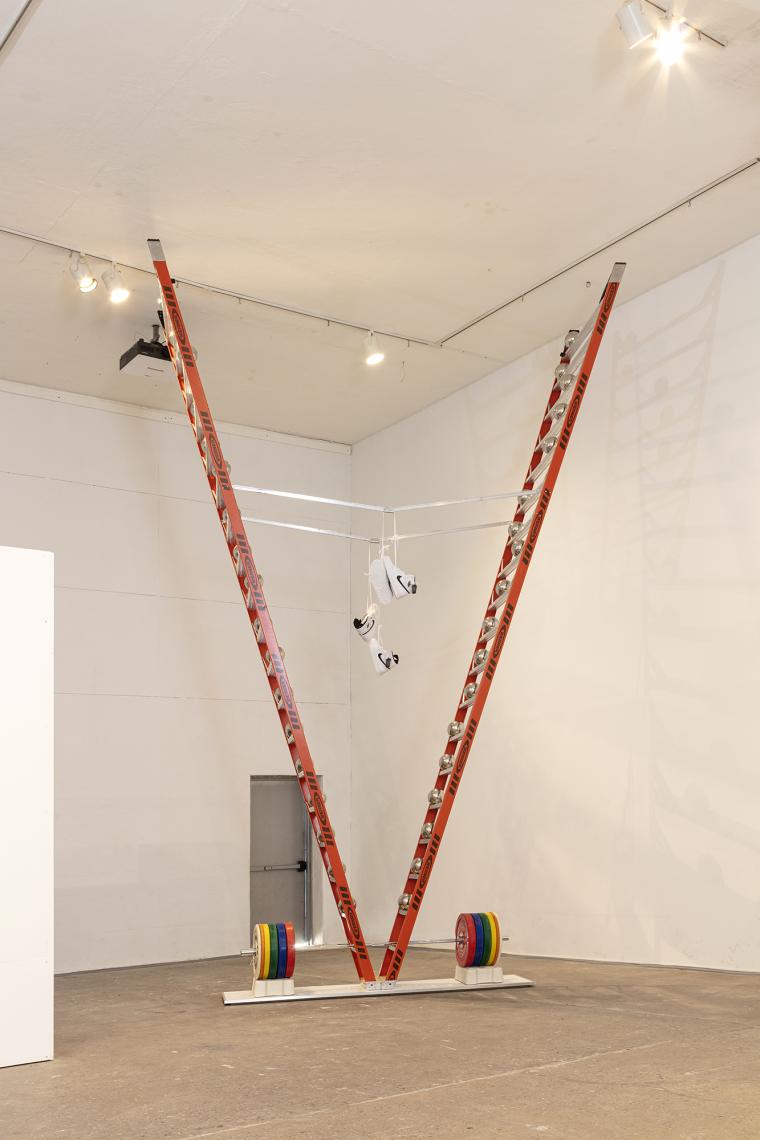 Sculpture made of upside down stepladder with with various objects hung on it